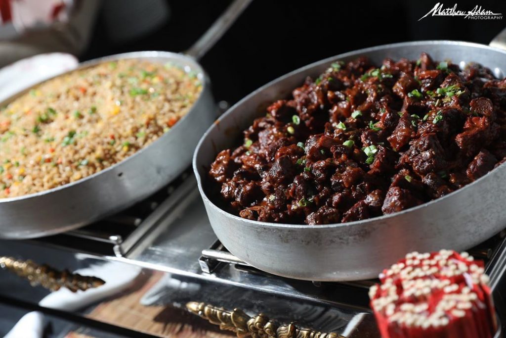 Meat and rice each in a serving dish at a catered event