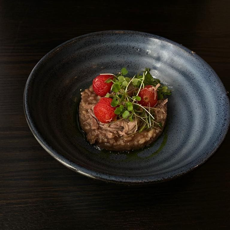 risotto topped with tomatoes and microgreens