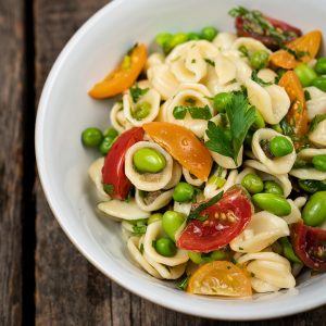 a bowl of pasta with fresh vegetables