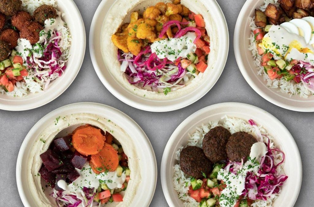 5 bowls filled with colorful vegetables, rice and falafel