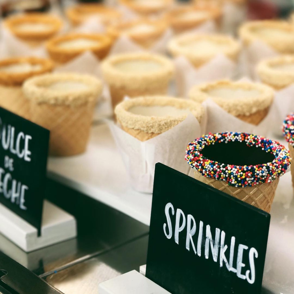 A display of waffle cone cups with different toppings
