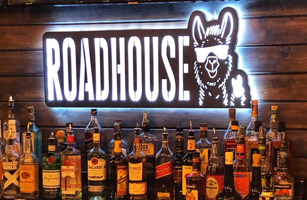 bottles of alcohol lined up at a bar