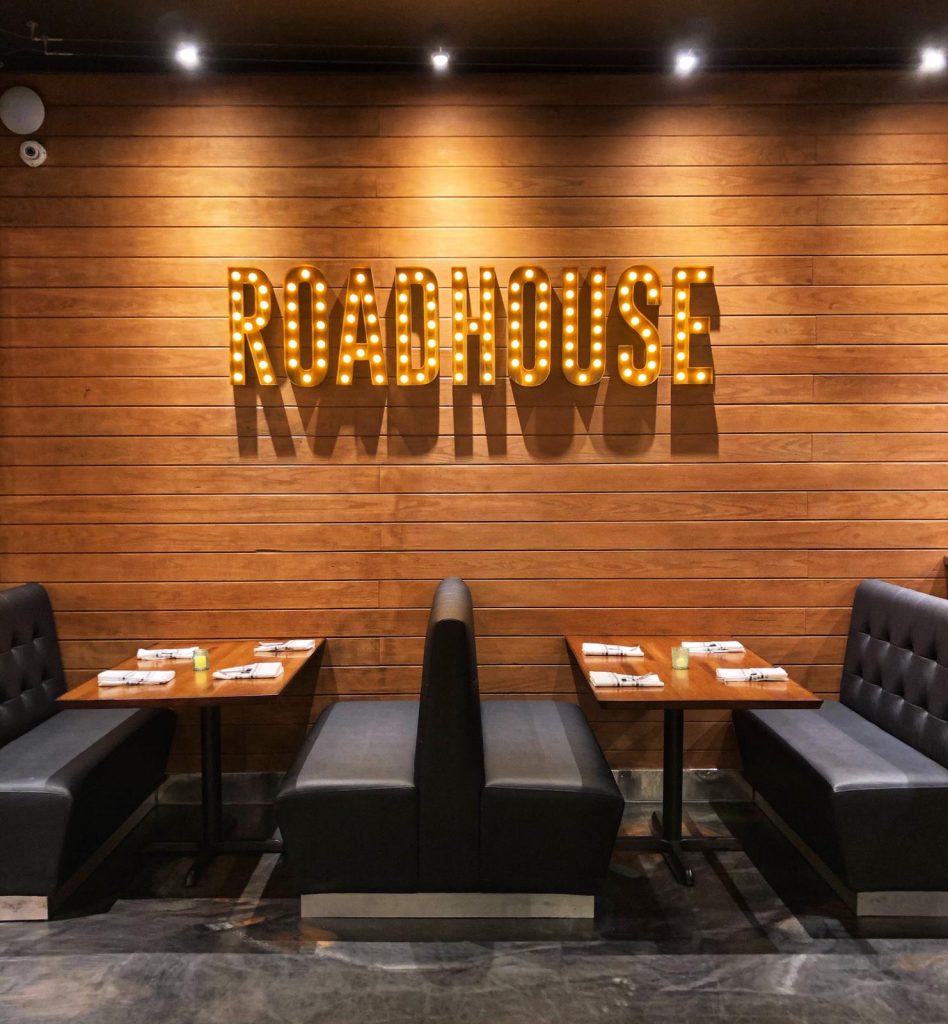 a restaurant booth with the restaurant name on the wall above