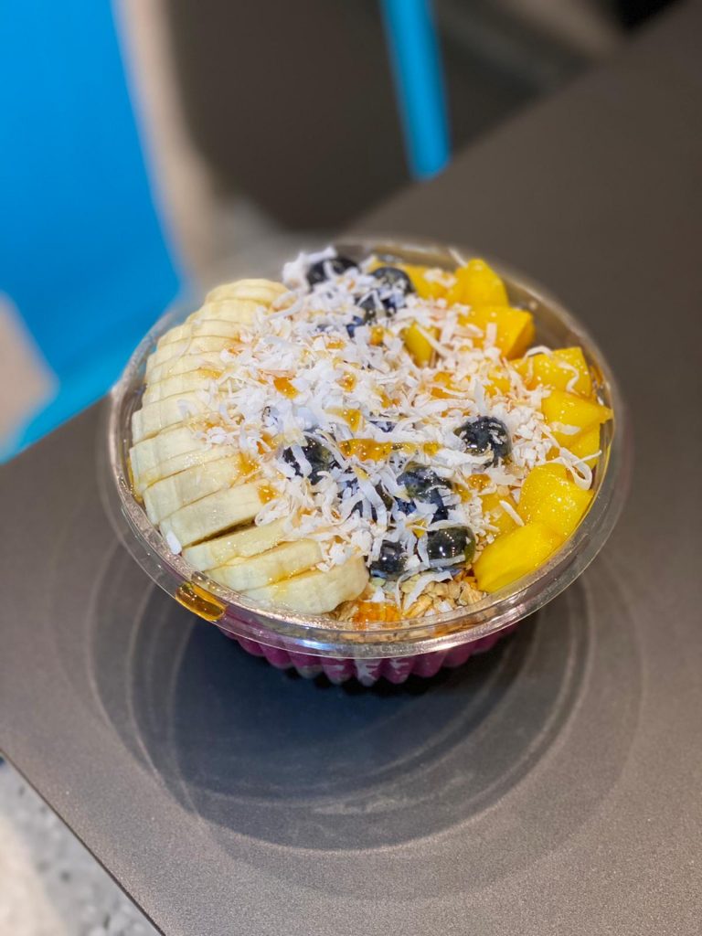 an acai bowl with fruit and coconut