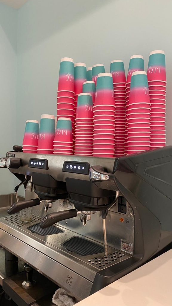 pink and blue cups stacked on a coffee machine