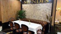 the word Mendi's on a wall above a table in a restaurant