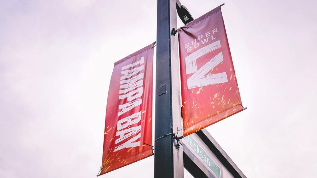 looking up at a sign for Superbowl LV hanging from a light pole in Tampa, Florida