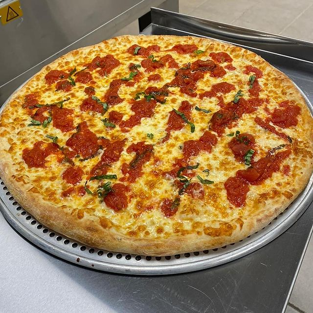a pizza topped with dollops of tomato sauce