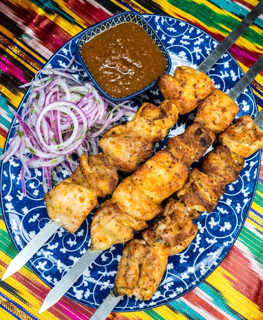 Chicken skewers with red onion salad at Chayhana Samarkand, a kosher Bukharian restaurant in Hallandale Beach, FL